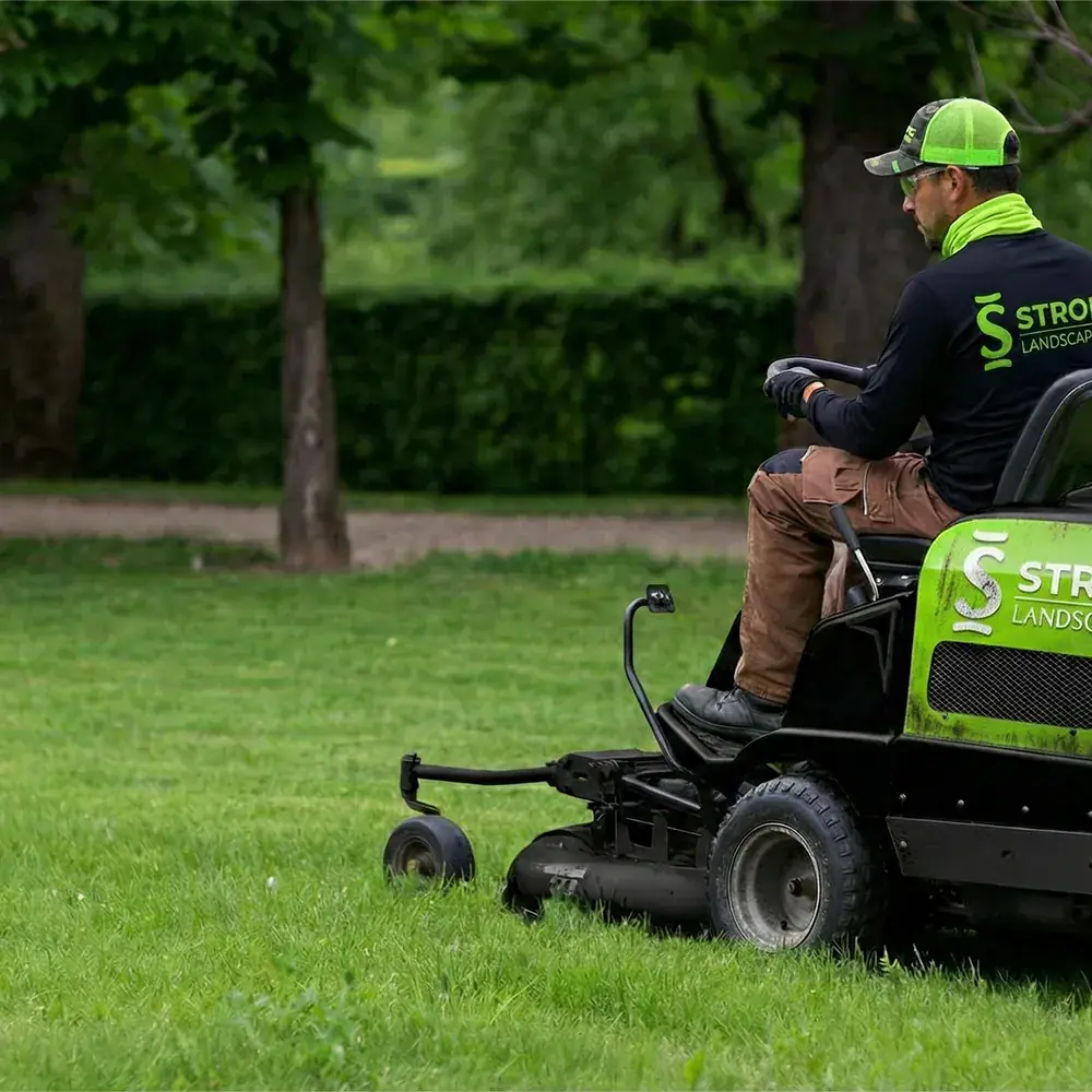 Strong Landscape lawn maintenance crew member on a riding mower